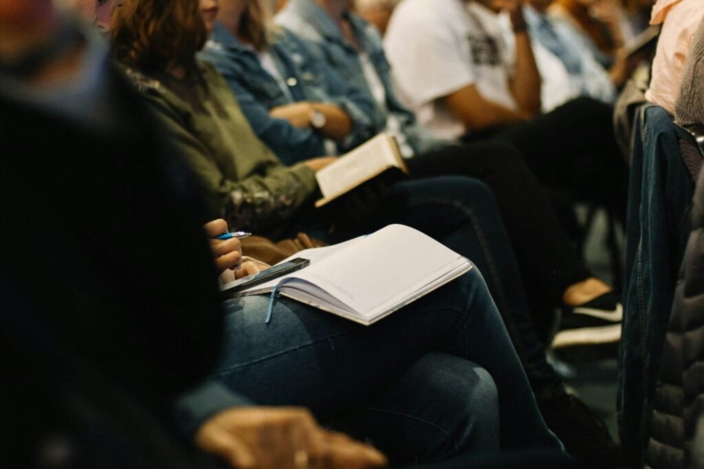 Congregation members taking notes during a sermon