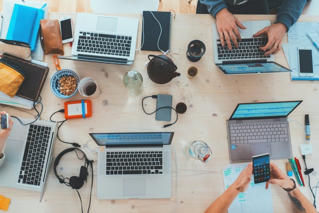 Overhead view of a team working on laptops at a shared desk