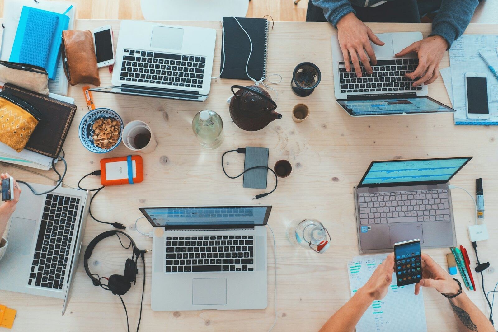 Overhead view of a team working on laptops at a shared desk