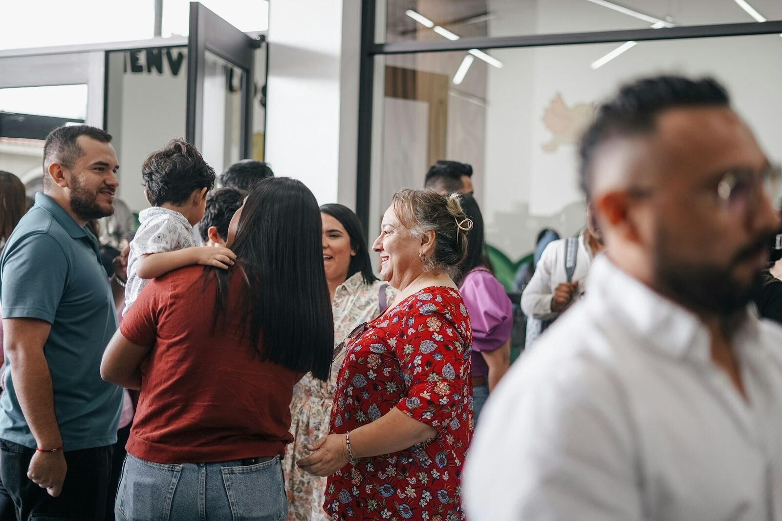 Church members greeting each other warmly in a welcome area
